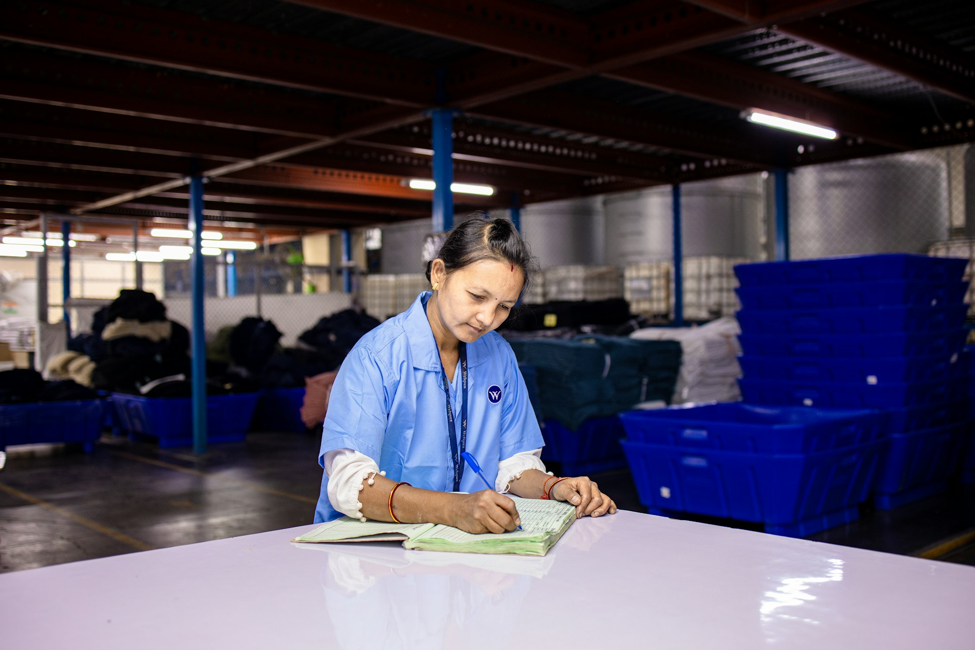 A woman writes at a work table.